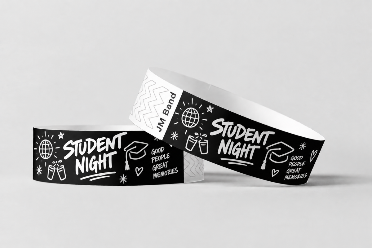 Twee zwarte papieren polsbandjes met witte opdruk voor een studentenavond